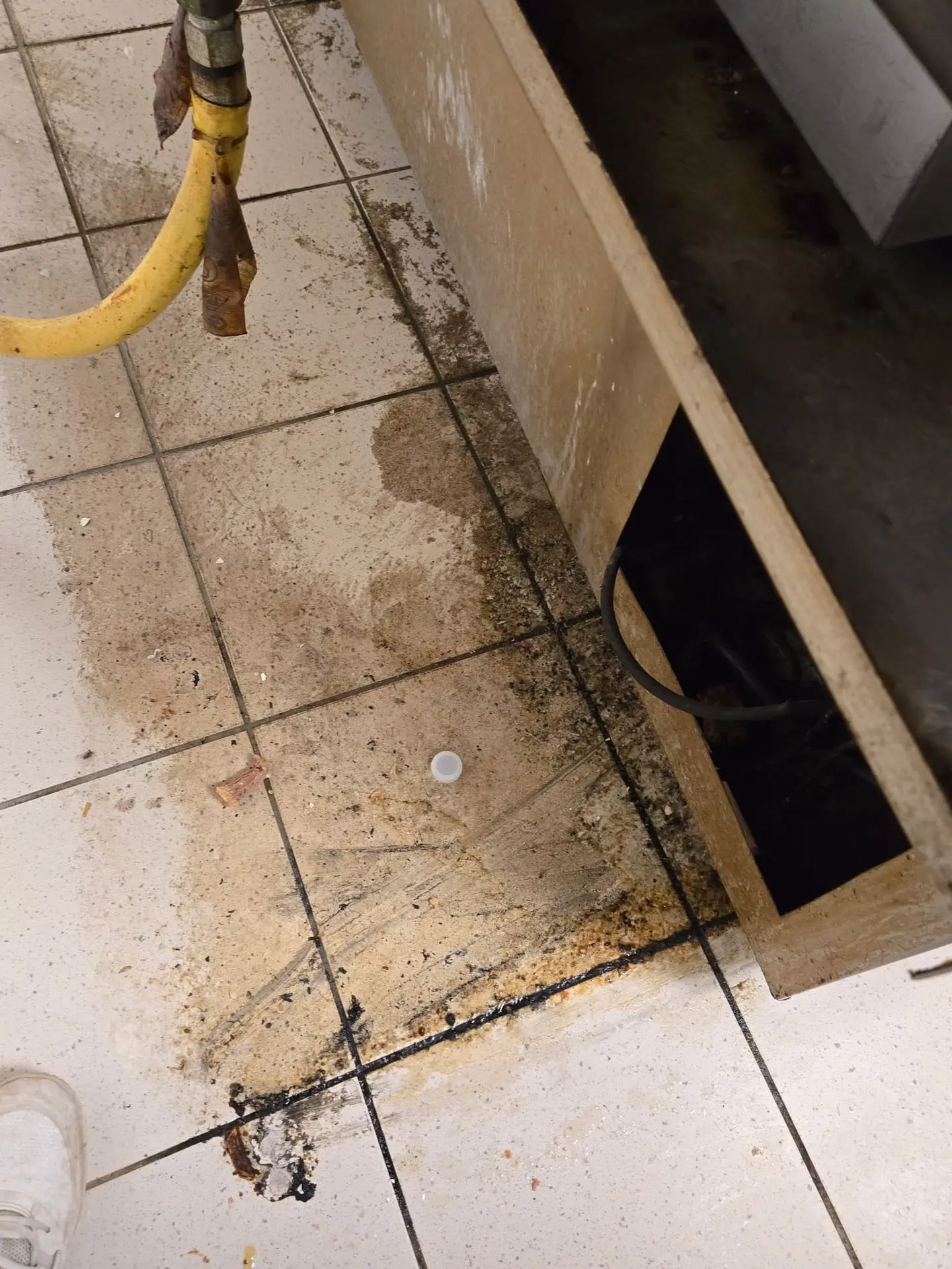 Commercial kitchen floor with grease buildup before cleaning